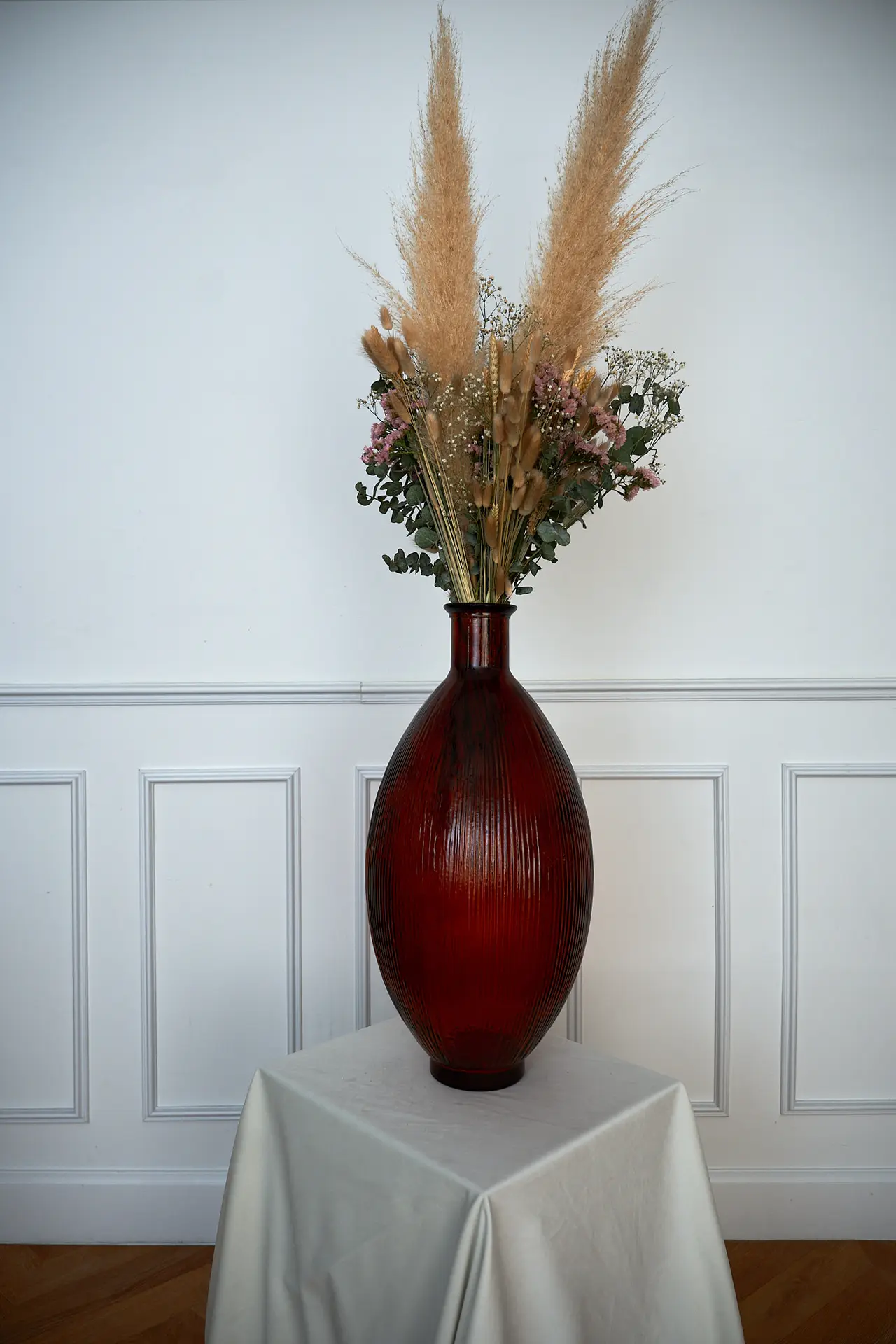 Tall red vase with dried pampas